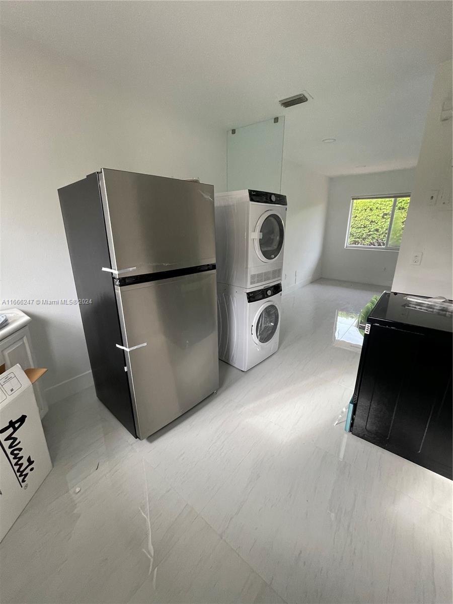 3112 Southwest 16th Street, Unit 3110 Miami, FL 33145 - Photo 10 of 19 a kitchen with refrigerator and white cabinets