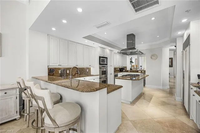 a kitchen with stainless steel appliances kitchen island granite countertop a sink and cabinets