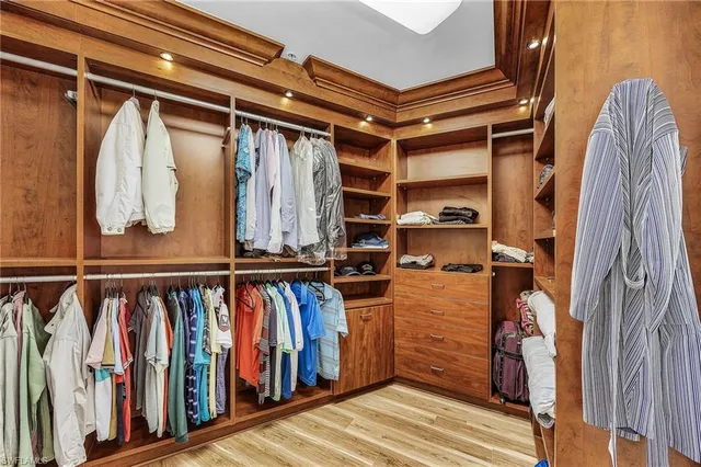 a view of walk in closet with clothes and shoes