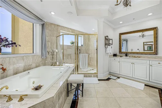 a bathroom with a tub a sink a mirror and a shower