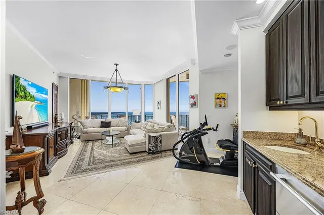 a living room with furniture kitchen view and a window
