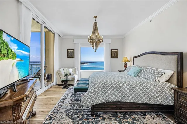 a bedroom with a bed dresser and a flat tv screen on dresser