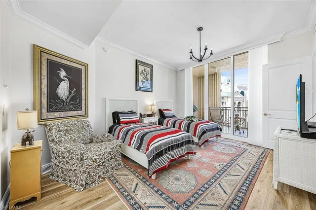 a bedroom with a bed wooden floor and flat screen tv