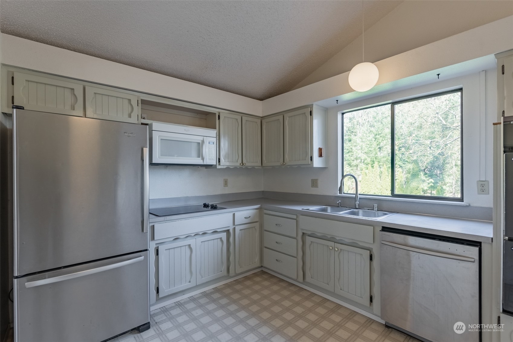 1004 Shaw Road Ferndale, WA 98248 - Photo 9 of 36 a kitchen with a sink cabinets stainless steel appliances and a window