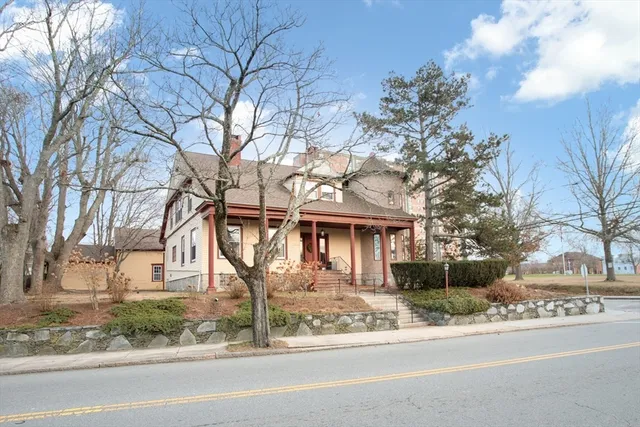 a front view of a house with garden and trees