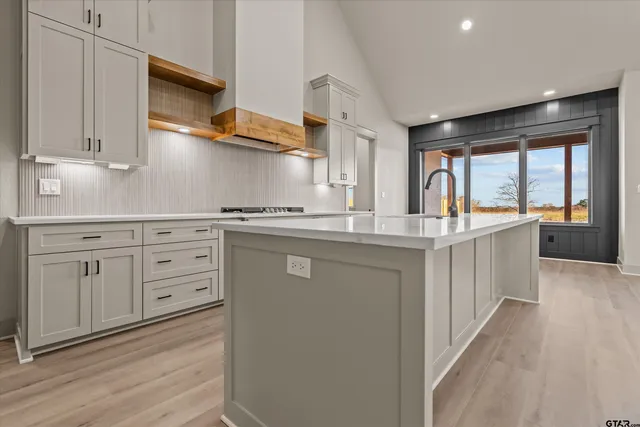 a kitchen with white cabinets and sink