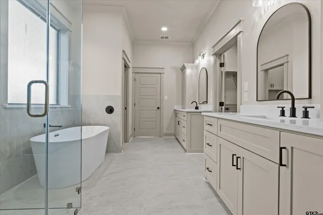 a spacious bathroom with a double vanity sink a mirror and a bathtub
