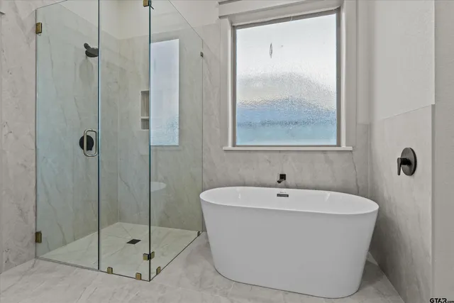 a white bath tub sitting next to a shower