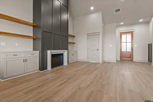 an empty room with windows and fireplace