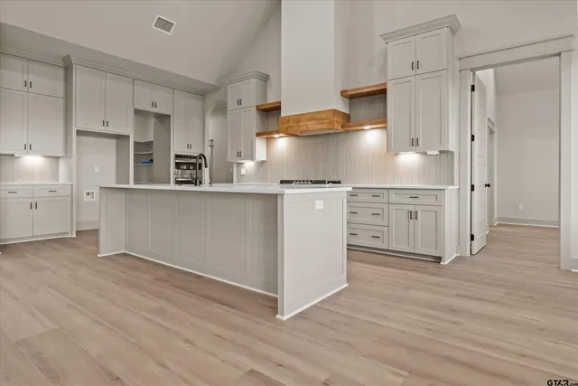 a kitchen with stainless steel appliances granite countertop a refrigerator and a stove top oven
