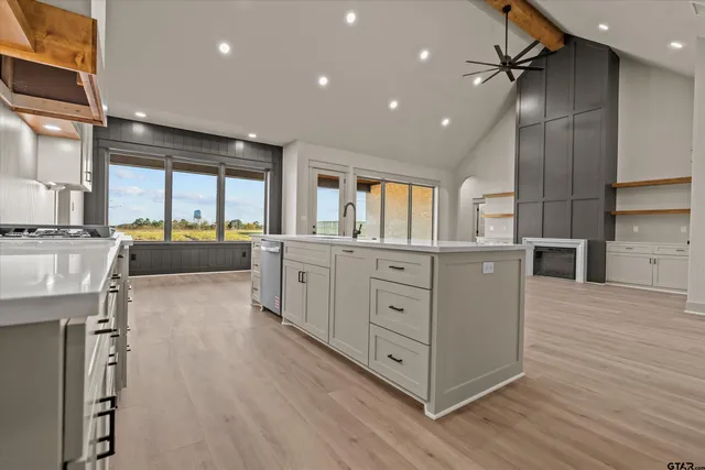 a large kitchen with stainless steel appliances a lot of counter space and wooden floors