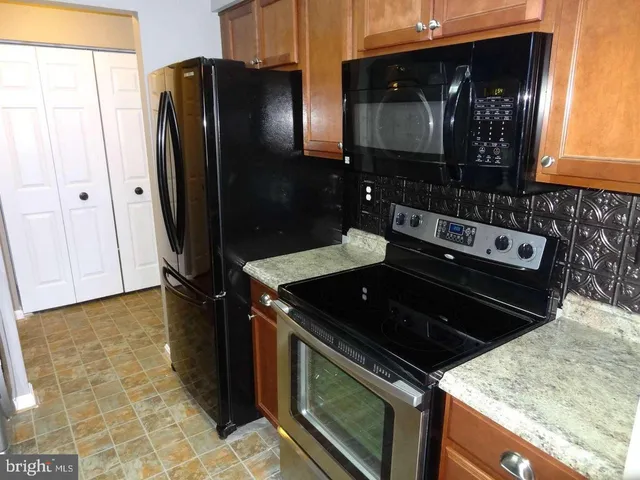 a kitchen with granite countertop a refrigerator and a stove