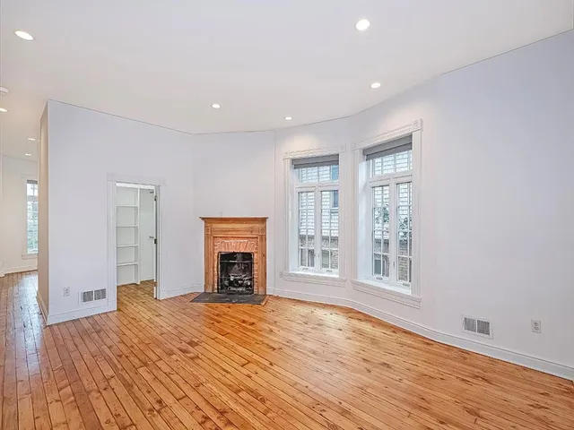 a view of empty room with wooden floor and fireplace