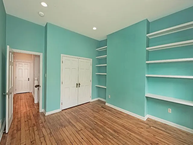 a view of a room with wooden floor and closet