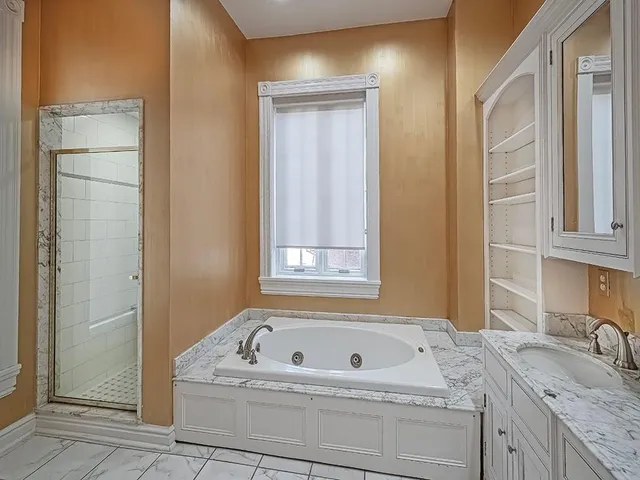 a bathroom with a granite countertop sink a mirror and a bathtub