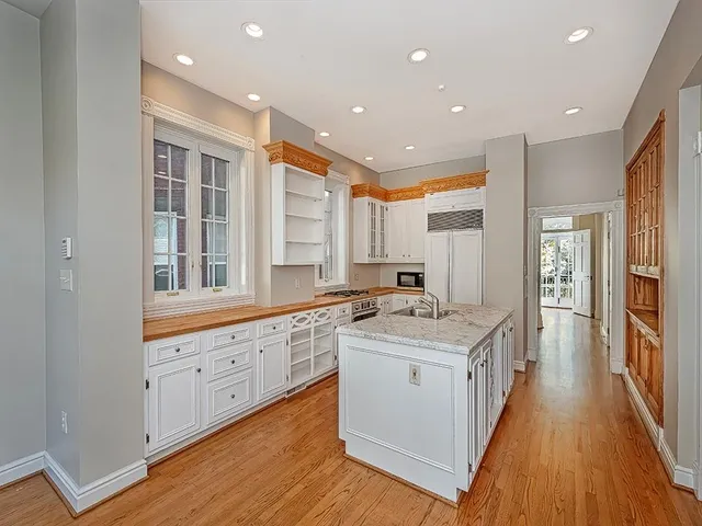 a large kitchen with stainless steel appliances granite countertop a stove and a large window