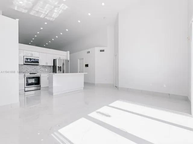 a view of kitchen with microwave and cabinets