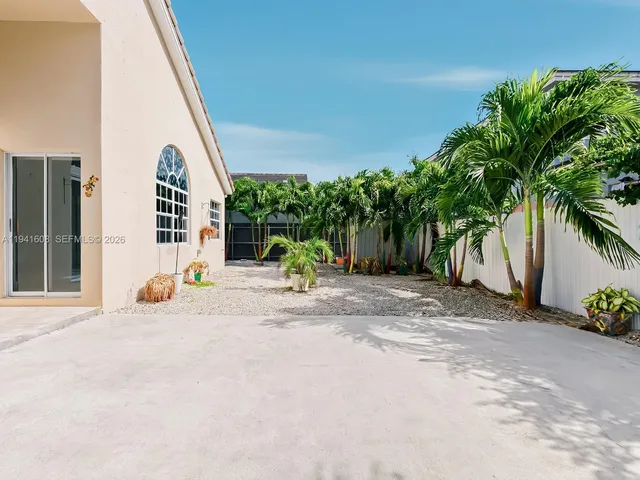 a view of a house with backyard and sitting area