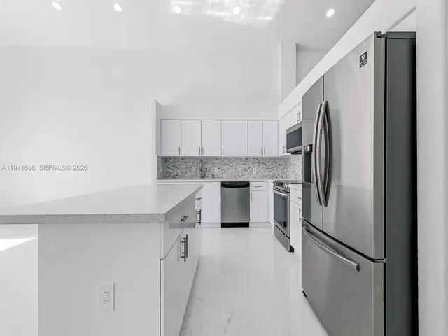 a kitchen with stainless steel appliances a refrigerator sink and cabinets