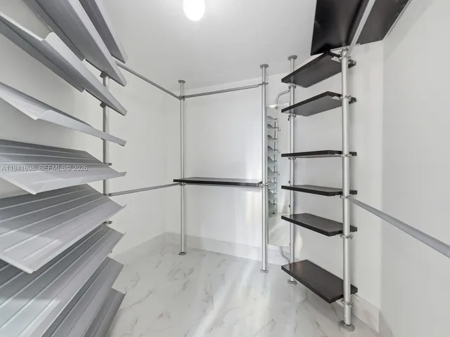 a view of walk in closet with empty racks
