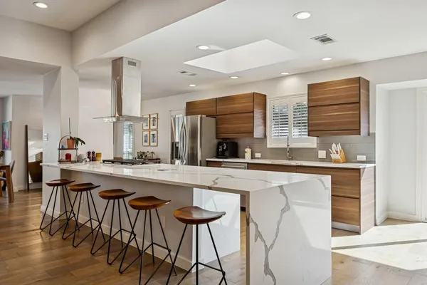a kitchen with a sink and chairs