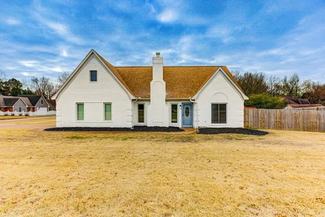 a view of a white house with a yard