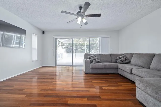a view of a room with wooden floor fan and window