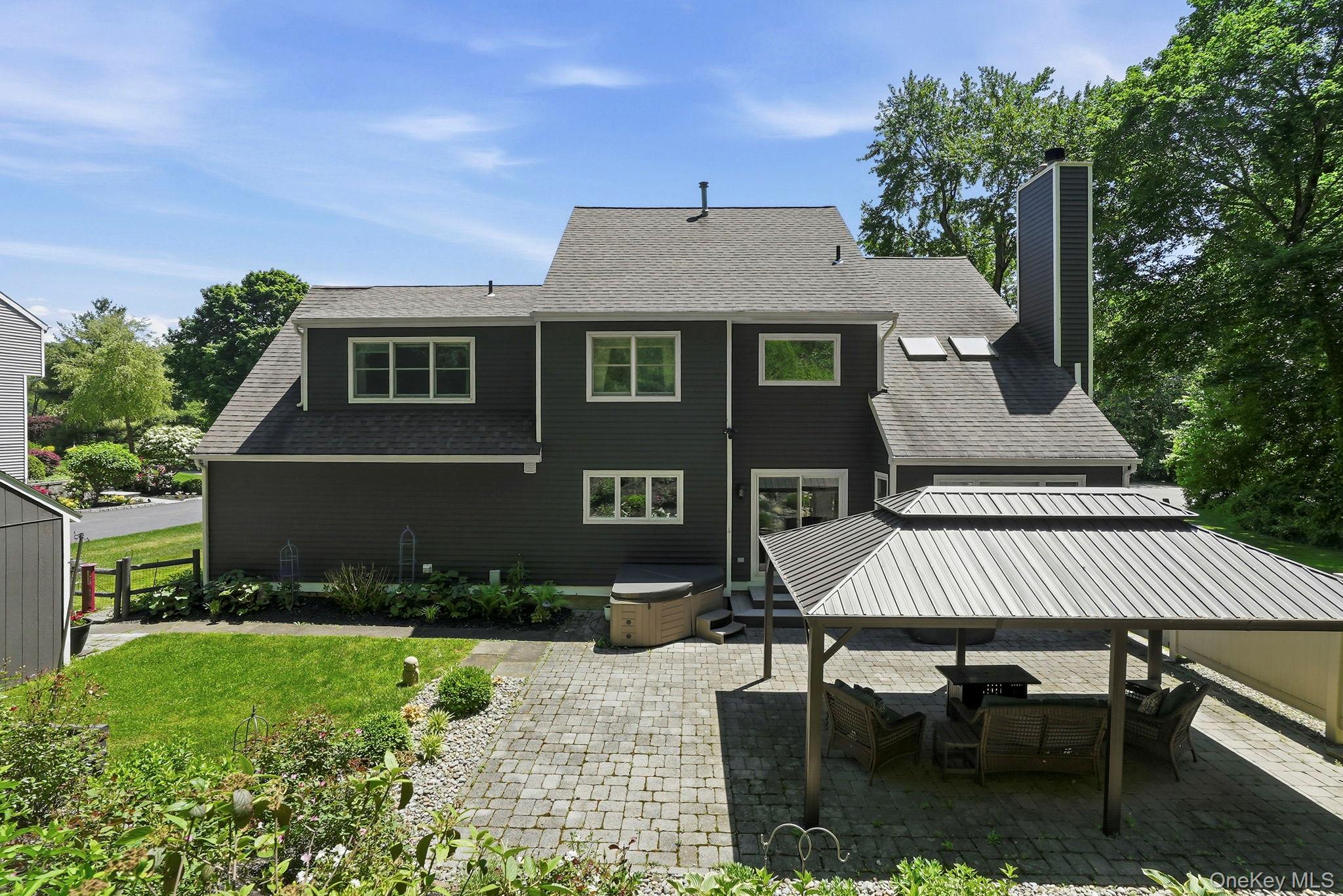 31 Ridge Road Cortlandt Manor, NY 10567 - Photo 33 of 39 Step out from the kitchen to a level, stone patio with a pergola.
