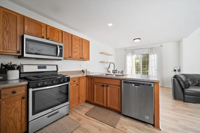 a kitchen with stainless steel appliances granite countertop a stove top oven microwave and cabinets