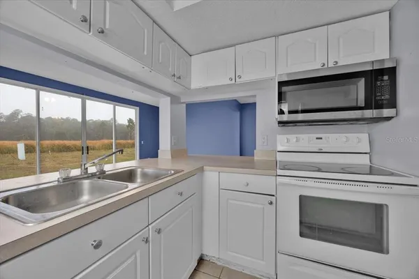 a kitchen with appliances a sink and cabinets
