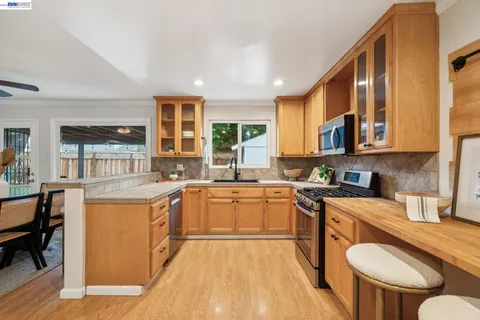 a kitchen with a refrigerator a stove a sink and a dishwasher with wooden floor