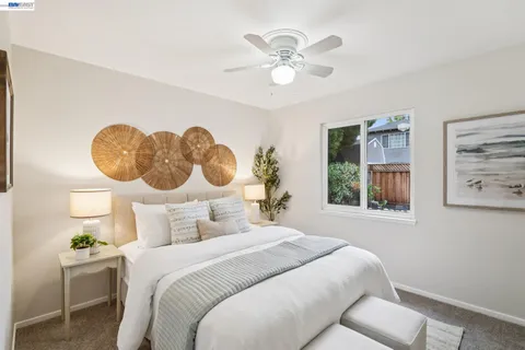 a bedroom with a bed and a painting on the wall