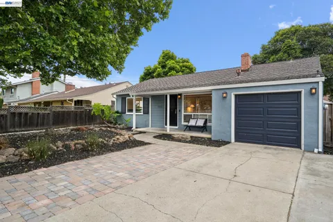 a view of house with backyard and glass windows