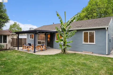 a backyard of a house with table and chairs