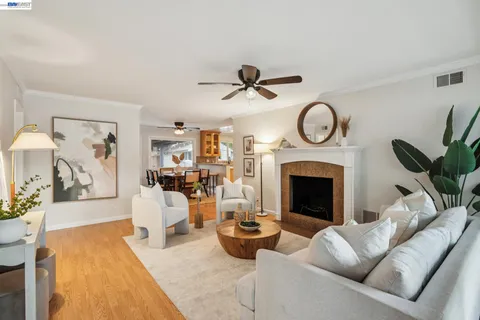 a living room with furniture a clock and a fireplace