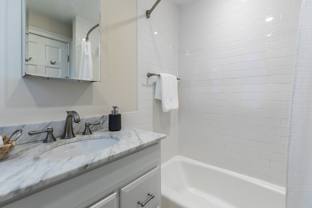 76 West Cedar Street, Unit 4F Boston, MA 02114 - Photo 16 of 22 a bathroom with a granite countertop sink a toilet and bathtub