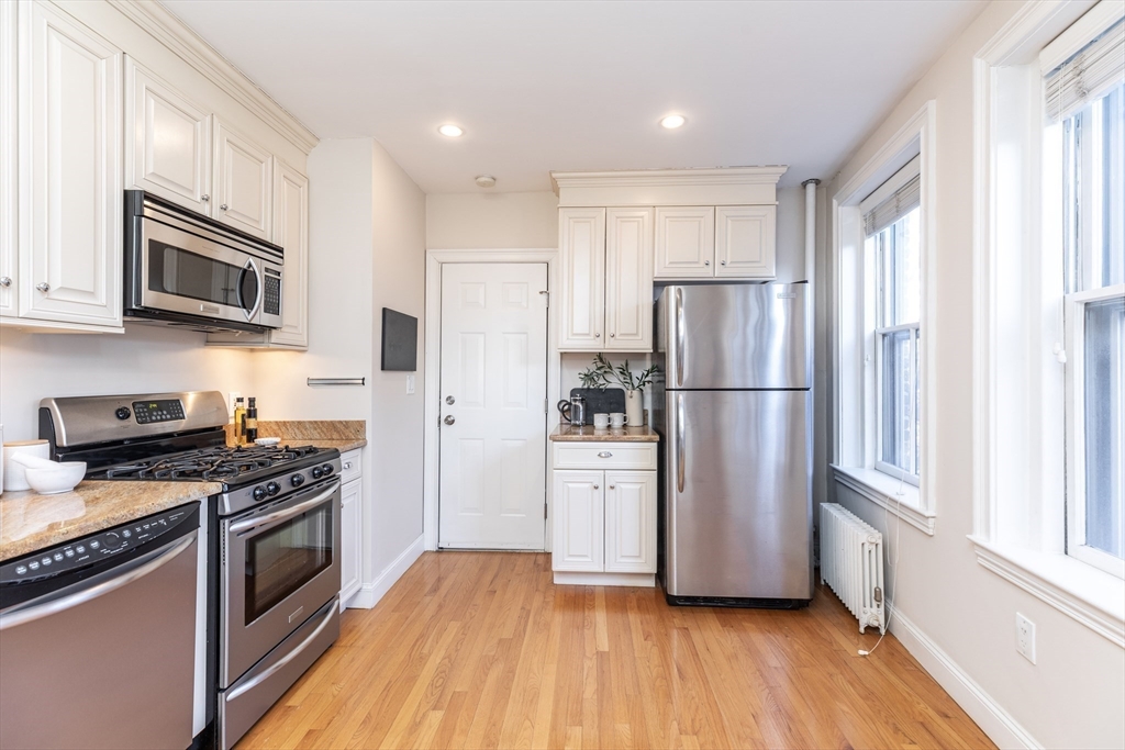 76 West Cedar Street, Unit 4F Boston, MA 02114 - Photo 7 of 22 a kitchen with stainless steel appliances a refrigerator stove and microwave