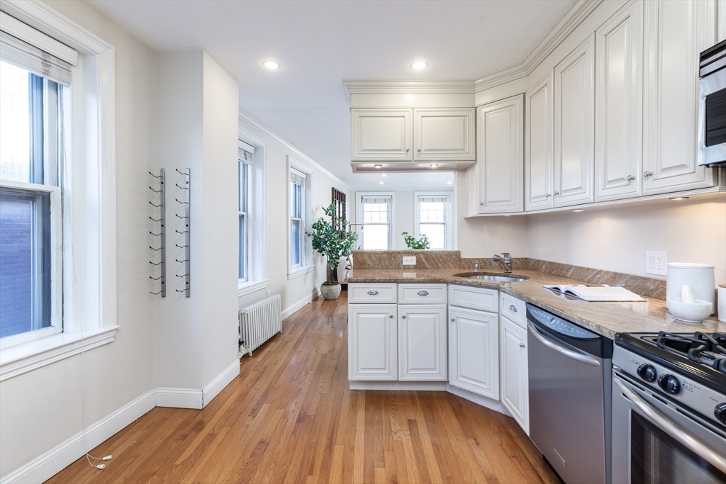 76 West Cedar Street, Unit 4F Boston, MA 02114 - Photo 8 of 22 a kitchen with granite countertop a sink cabinets stainless steel appliances and a window