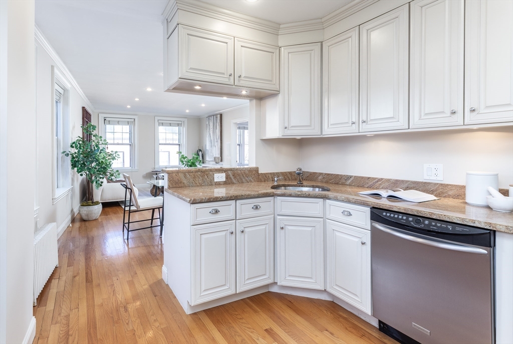 76 West Cedar Street, Unit 4F Boston, MA 02114 - Photo 9 of 22 a kitchen with granite countertop a white cabinets and chandelier