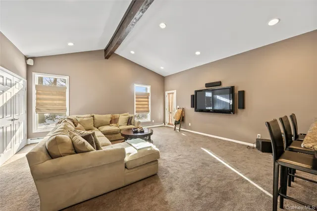 a living room with furniture a flat screen tv and a window