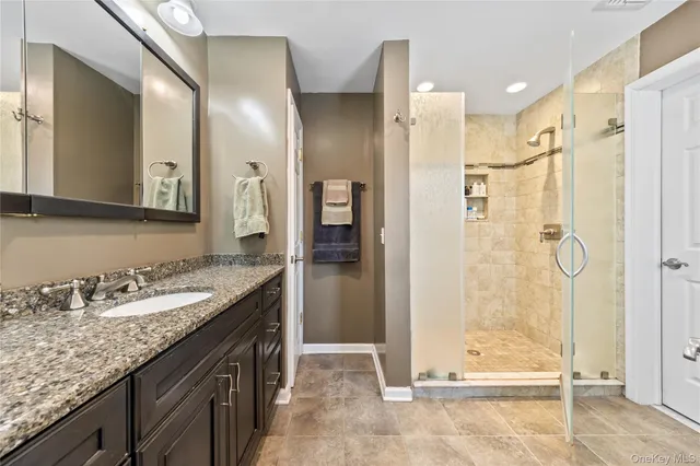 a bathroom with a granite countertop sink shower and a mirror