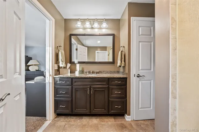 a bathroom with a granite countertop sink a mirror and a vanity