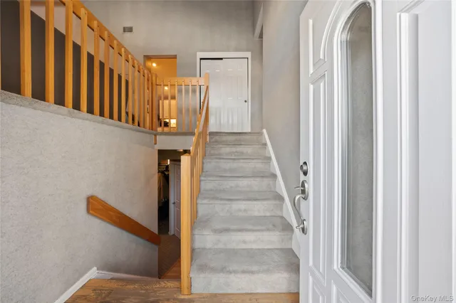 a view of staircase with lots of frames on wall and a window