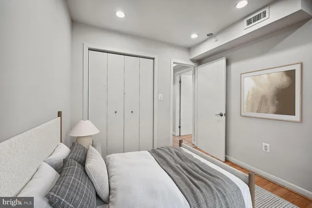 a bedroom with a bed and a painting on the wall