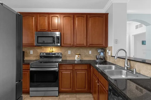 a kitchen with stainless steel appliances granite countertop a sink stove and microwave