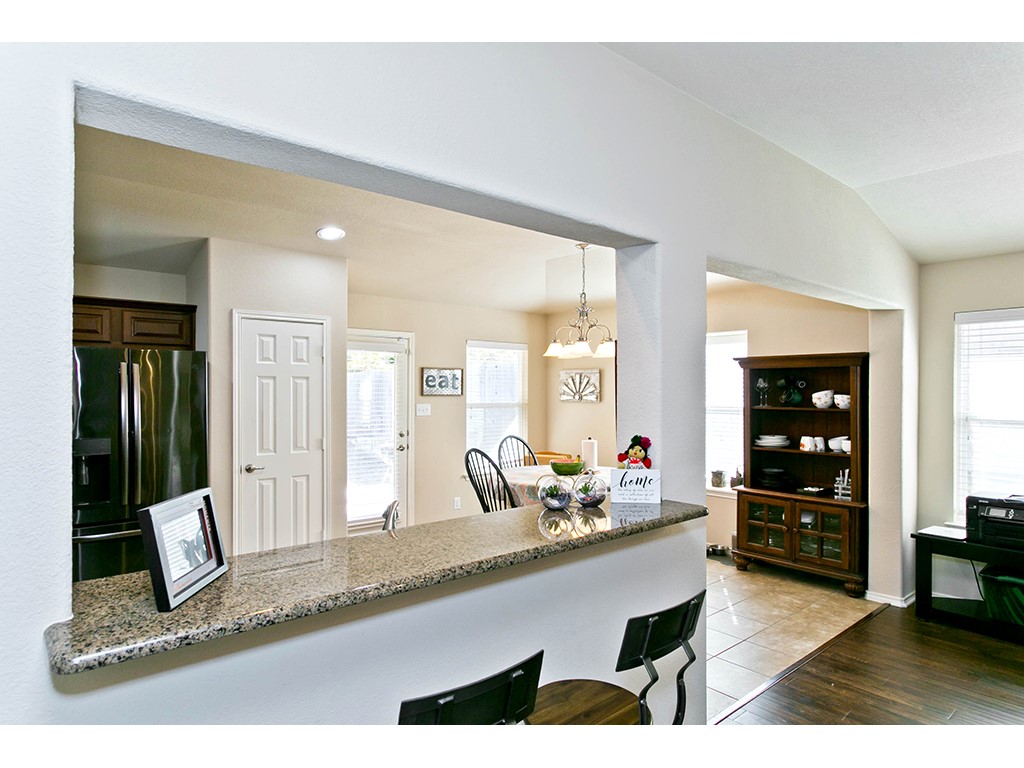 1808 Sand Creek Road Cedar Park, TX 78613 - Photo 21 of 25 Kitchen pass-through featuring a granite countertop