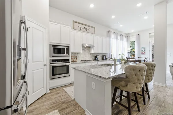 a kitchen with stainless steel appliances granite countertop a stove a sink and a refrigerator