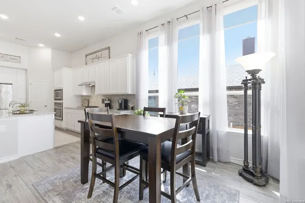 a kitchen with stainless steel appliances granite countertop table chairs sink and stove