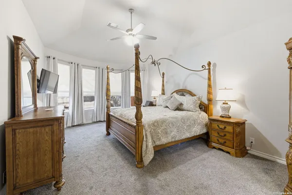 a bedroom with a bed and a dresser with mirror