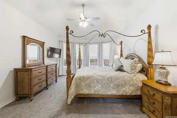a bedroom with a bed a chandelier and dresser